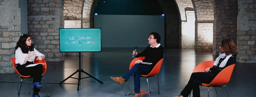 2 invités et une journaliste échangeant sur un plateau TV dans une salle de la cité de l'architecture de Paris