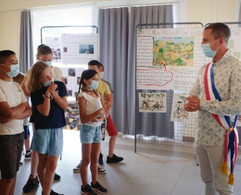 Enfants écoutant l'intervention d'un maire