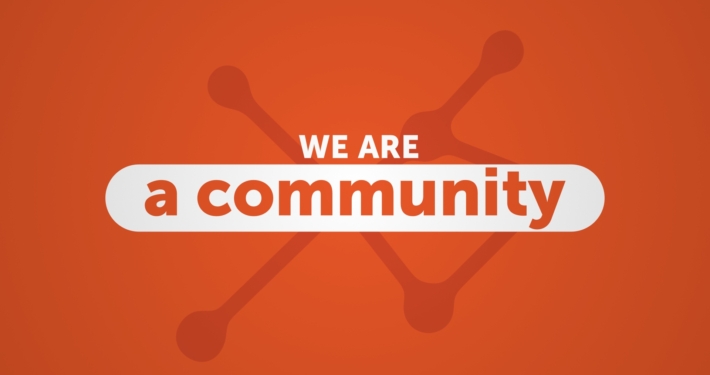 Les mots "we are a community" sur un fond orange