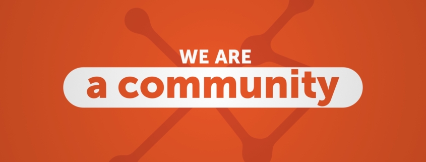 Les mots "we are a community" sur un fond orange