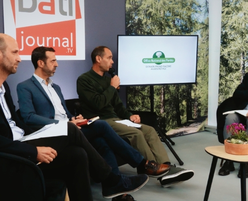 Trois personnes échangeant avec un journaliste sur un plateau TV réalisé dans le cadre d'un salon.