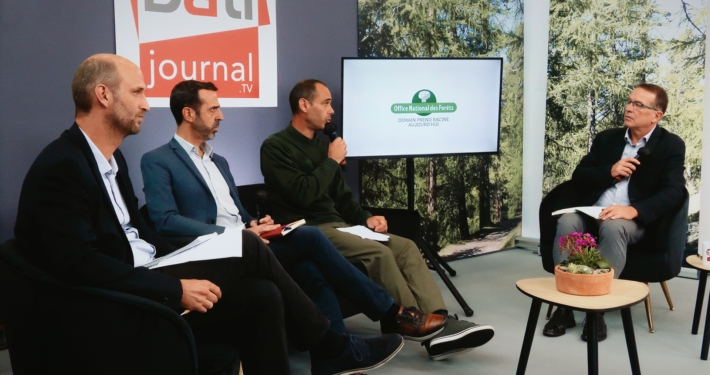 Trois personnes échangeant avec un journaliste sur un plateau TV réalisé dans le cadre d'un salon.