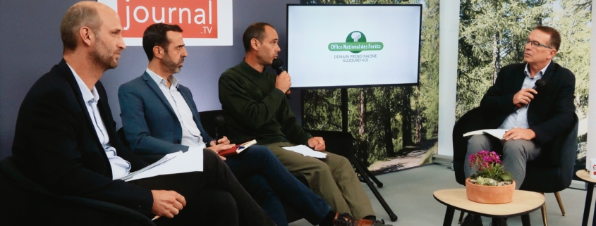 Trois personnes échangeant avec un journaliste sur un plateau TV réalisé dans le cadre d'un salon.