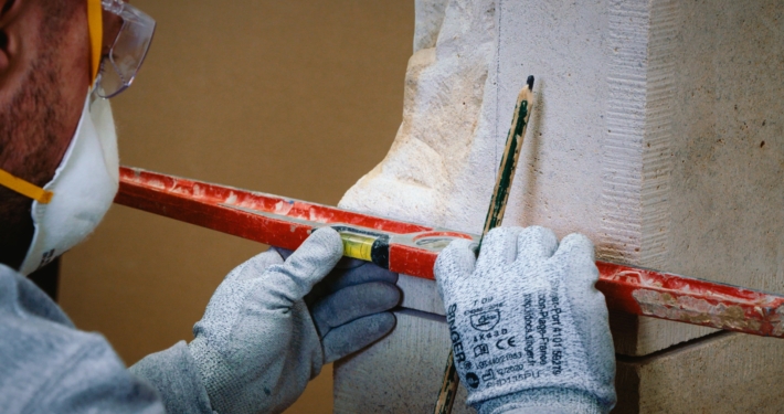 Artisan en train de faire un tracé au niveau sur une ancienne pierre de taille