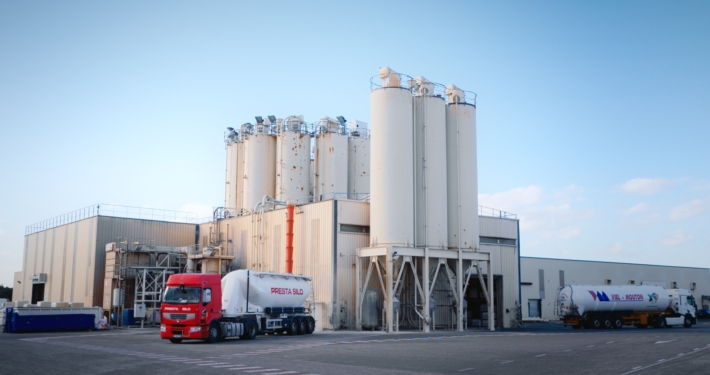 Photo d'une usine dans la Sud de la France avec des silots et des camions.