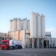 Photo d'une usine dans la Sud de la France avec des silots et des camions.