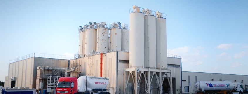 Photo d'une usine dans la Sud de la France avec des silots et des camions.