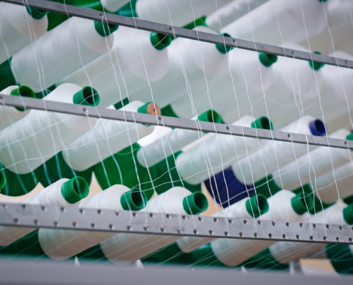 Rouleaux de fils blanc sur un métier à tisser