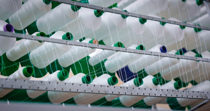 Rouleaux de fils blanc sur un métier à tisser